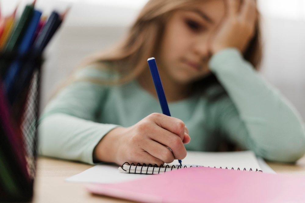 niña-aburrida-haciendo-deberes-clase