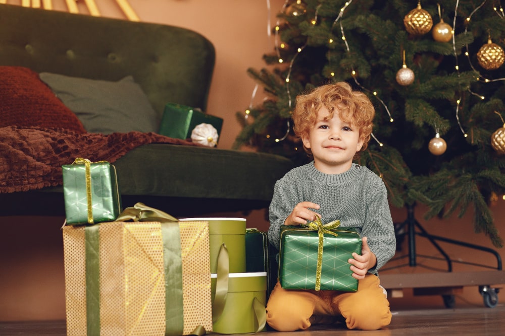 Niño en navidad con regalos. Freepik