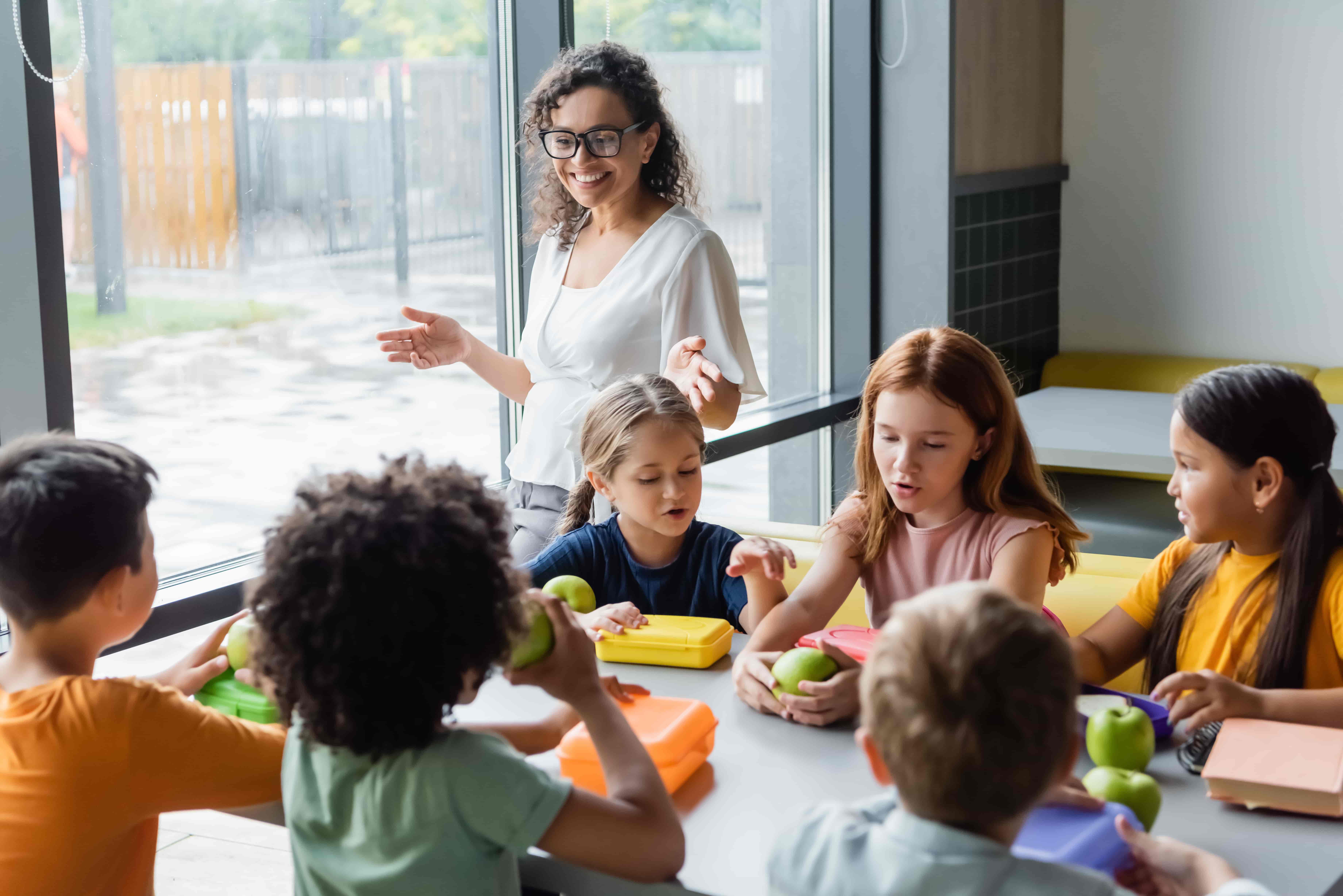 Alumnos almorzando en el aula con su maestra