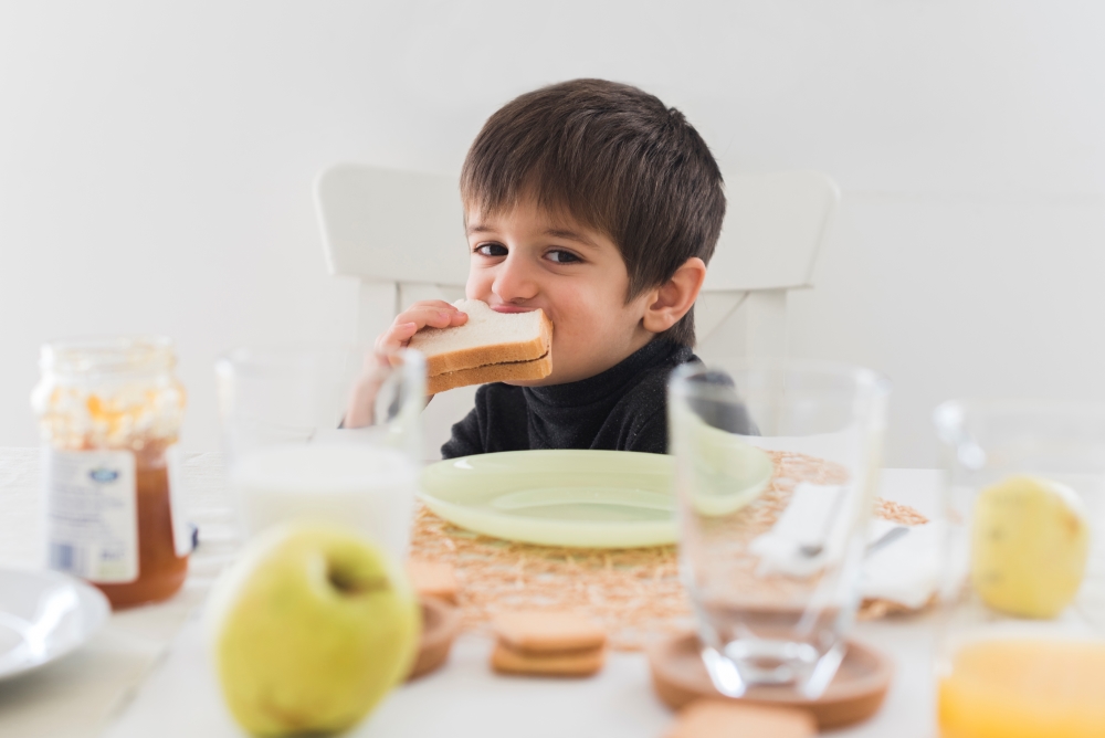 Niño comiendo desayuno completo