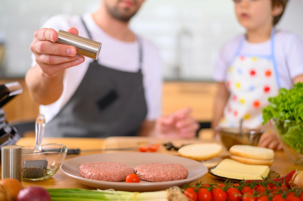 Padre e hijo cocinando hamburguesa