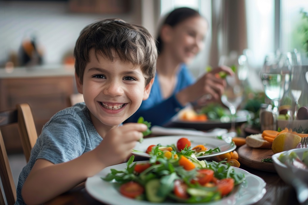 Niño comiendo ensalada junto con su familia