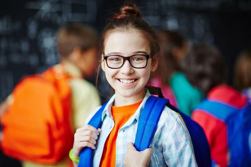 Niña con gafas en la escuela - Imagen de adobe stock